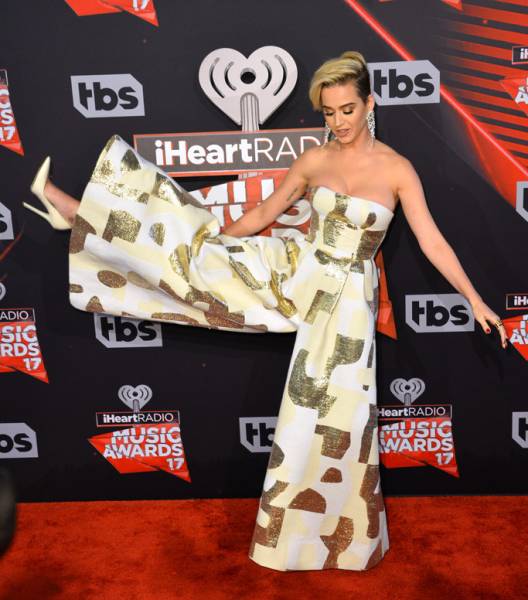 Katy Perry Kicks Up Her Jimmy Choo Heels Clad In An August Getty Atelier Jumpsuit At The 2017 IHeartRadio Music Awards Red Carpet