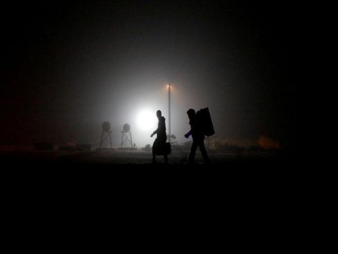 FILE PHOTO: Migrants walk along railway tracks after crossing the Canada-U.S. border in Emerson Canada wants U.S. cooperation in turning back asylum seekers, Politics News, Latest Politics News, Politics News Usa, Politics Live News, Top Politics News, Politics Live News Online