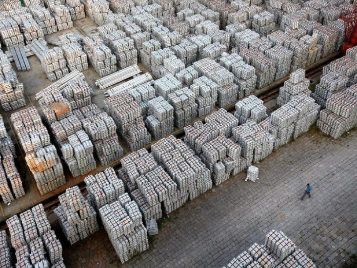 FILE PHOTO: A worker walks through an aluminium ingots depot in Wuxi, Jiangsu province Dollar goes positive for year before Fed meeting, Business News Today, Live Updates News, latest Business News USA, Business News, Latest and Daily Business News