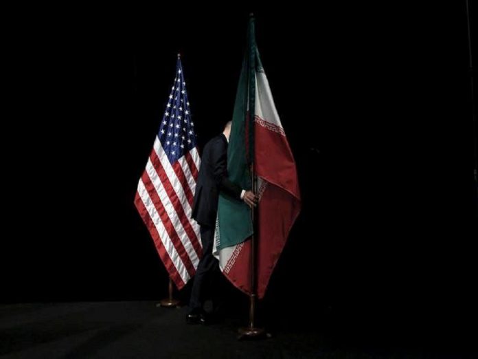 FILE PHOTO: A staff member removes the Iranian flag from the stage after a group picture with foreign ministers and representatives during the Iran nuclear talks at the Vienna International Center in Vienna Less than one in three Americans support U.S. pullout from Iran deal, Politics News, Latest Politics News, Politics News Usa, Politics Live News, Top Politics News, Politics Live News Online